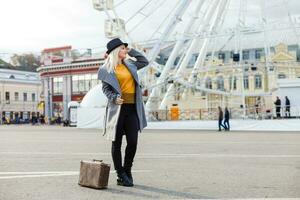 The young girl walks around the city near sights. Ferris wheel. Amusement park. autumn photo