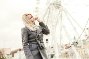 Stylish woman posing near ferris wheel photo