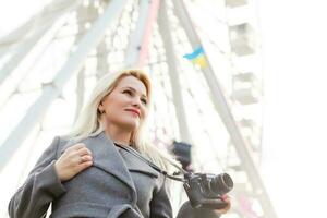 The young girl walks around the city near sights. Ferris wheel. Amusement park. autumn photo