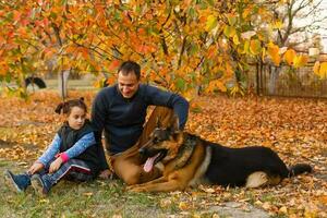 Happy father and daughter in autumn park on yellow leaves photo