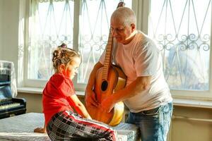 de cerca del hombre mano cambiando instrumentos de cuerda en su antiguo acústico guitarra. foto