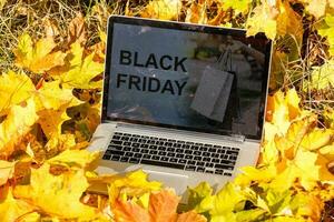 otoño venta, texto en digital tableta con otoño follaje y rústico de madera tablones antecedentes foto