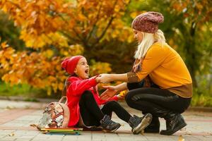 Parent take child to school. Pupil of primary school with backpack outdoors. Mother and daughter go hand in hand. Back to school. First day of fall. Elementary student. Kindergarten, preschool. photo