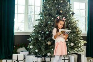 Happy little girl with Christmas tree photo