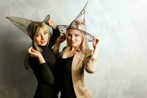 two young beautiful girls wearing witch black dress making party photo