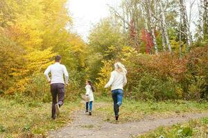Family with child go in autumn park photo