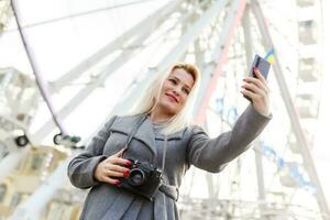 Stylish woman posing near ferris wheel photo