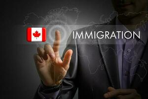 Canada immigration concept. Man pressing virtual button with flag icon photo