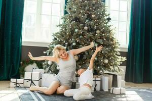 Happy family mother and child girl near a Christmas tree with Christmas present photo