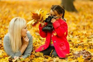 madre y hija en el ciudad parque en otoño teniendo divertido tiempo. foto