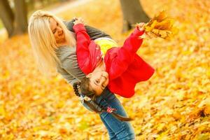 Cute family walking in a autumn park. Mother with little daughter photo