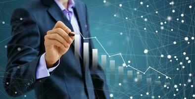 Businessman draw growth graph and progress of business and analyzing financial and investment data ,business planning and strategy on blue background photo