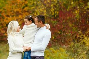 Family with child go in autumn park photo