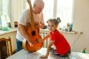 de cerca del hombre mano cambiando instrumentos de cuerda en su antiguo acústico guitarra. foto