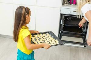 pequeño niña hacer galletas a el adviento tiempo. foto