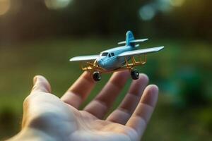 close up photo of male hand holding toy airplane against blue sky . image is retro filtered