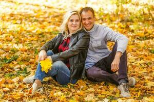 Young woman and man walking in autumn city park photo