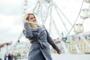 Stylish woman posing near ferris wheel photo