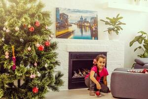 Child decorating Christmas tree Kid with Xmas gifts and toys. Little girl fireplace. Family with kids celebrate winter holidays. photo