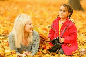 Cute family walking in a autumn park. Mother with little daughter photo