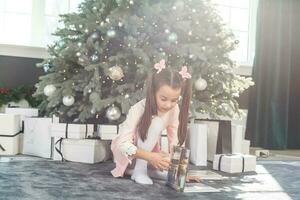 contento pequeño niña con Navidad árbol foto