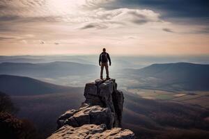 Back view of male manager carrying a suitcase while standing on the hills and looking at misty mountain. Shot at sunrise time photo