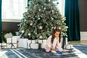 Happy little girl with Christmas tree photo