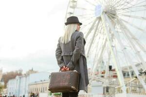 The young girl walks around the city near sights. Ferris wheel. Amusement park. autumn photo