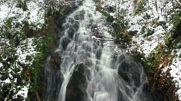 små vattenfall i snöig skog med låg slutare hastighet video