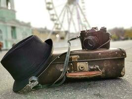 old camera and suitcase against the background of the ferris wheel photo