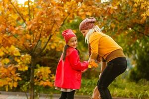 Parent take child to school. Pupil of primary school with backpack outdoors. Mother and daughter go hand in hand. Back to school. First day of fall. Elementary student. Kindergarten, preschool. photo
