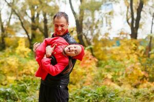 contento padre y hija en otoño parque en amarillo hojas foto