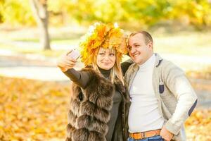 Young woman and man walking in autumn city park photo