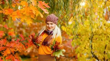 retrato de alegre joven mujer con otoño hojas en frente de follaje haciendo selfie foto