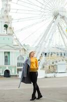 Stylish woman posing near ferris wheel photo