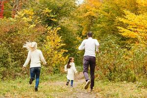 concepto de familia, infancia, temporada y personas - familia feliz en el parque otoño foto