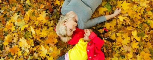 Mother and daughter in autumn yellow park. photo