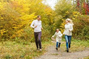 Family with child go in autumn park photo