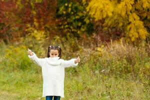 Little girl in autumn orange leaves. Outdoor. photo