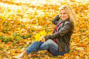 girl sitting in the autumn park photo