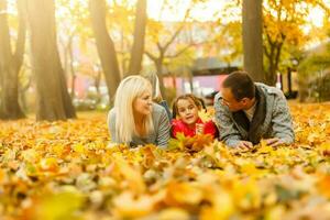 Happy beautiful family playing and laughing on autumn walk photo