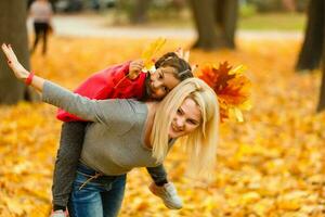 madre y hija en el ciudad parque en otoño teniendo divertido tiempo. foto