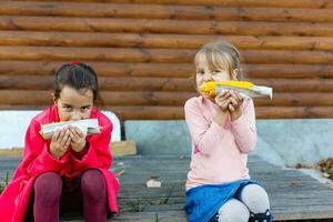 pequeño muchachas comiendo sucio maíz en el mazorca foto