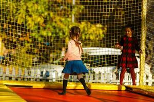 contento colegio niña saltando en trampolín en el otoño parque foto