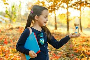 Autumn season leisure. Atmosphere of autumn. Adorable smiling schoolgirl autumn foliage background. Good mood. Happy child. Welcome october. United with nature. Little child walk in autumn park. photo