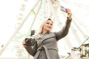 Stylish woman posing near ferris wheel photo