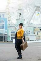 The young girl walks around the city near sights. Ferris wheel. Amusement park. autumn photo