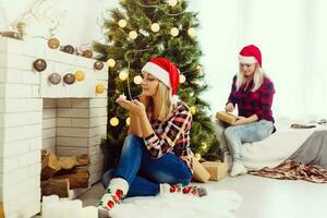 dos hermosa joven mujer en Navidad ropa posando terminado Navidad antecedentes. foto