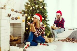 Two beautiful young women in Christmas clothes posing over Christmas background. photo