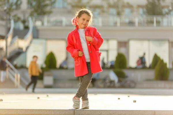 Cute little girl wearing red coat, grey leggings, and white sneakers.  Fashion concept 26461319 Stock Photo at Vecteezy